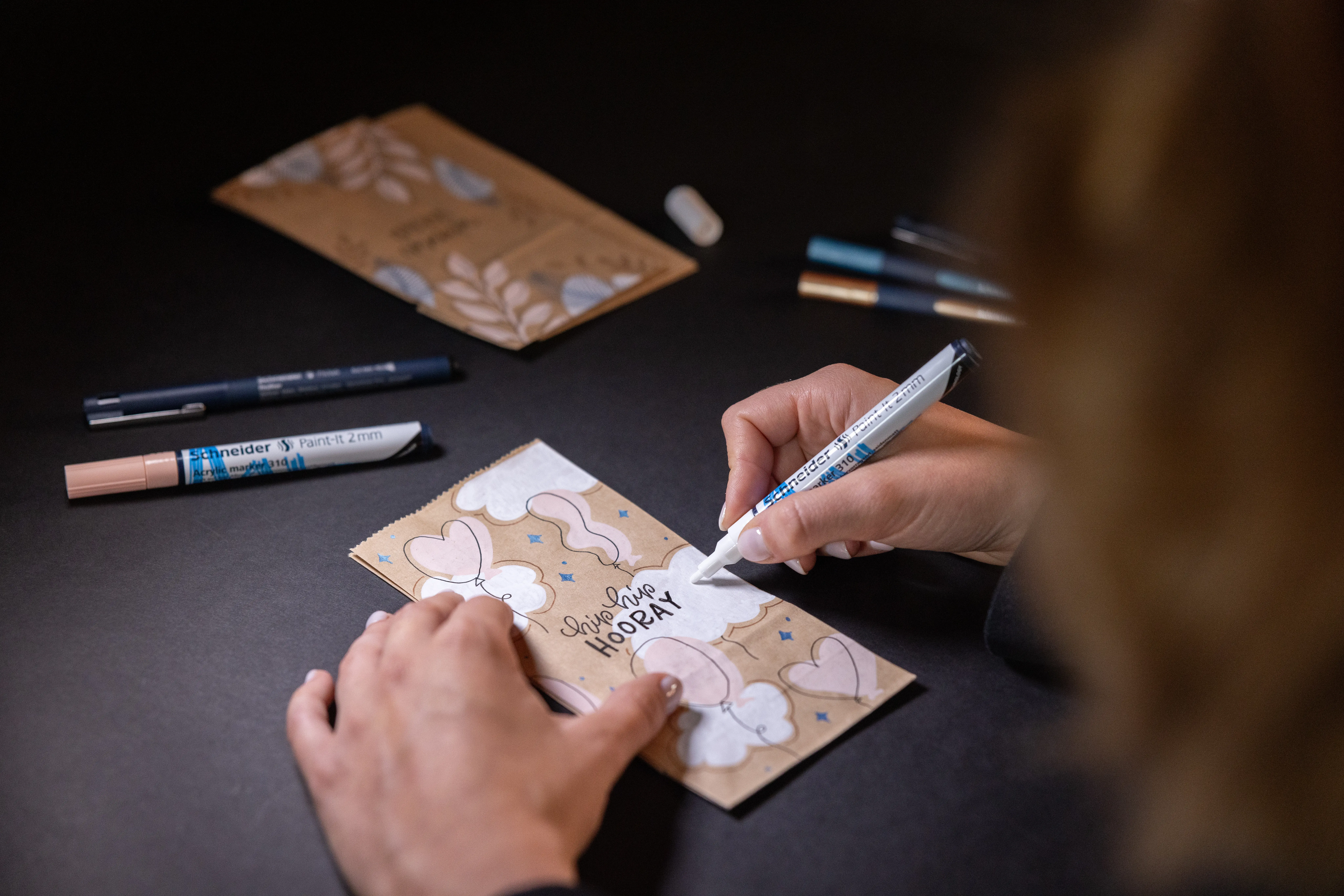 Frau gestaltet Geschenktüte aus dem DIY-Set von Schneider